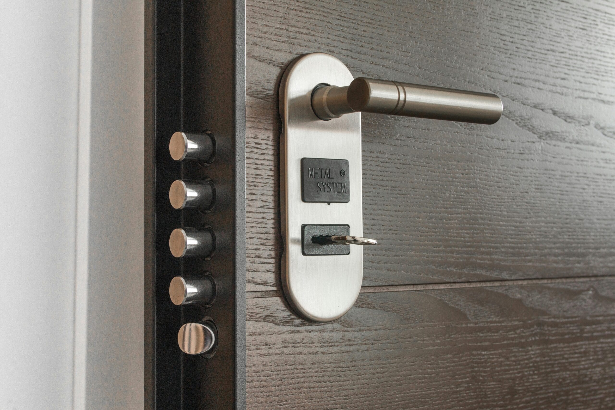 Metal door handle and lock system with key inserted, showcasing security features.